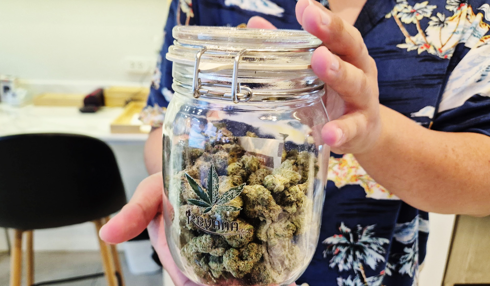 医療大麻の入ったジャーを持つスタッフの写真