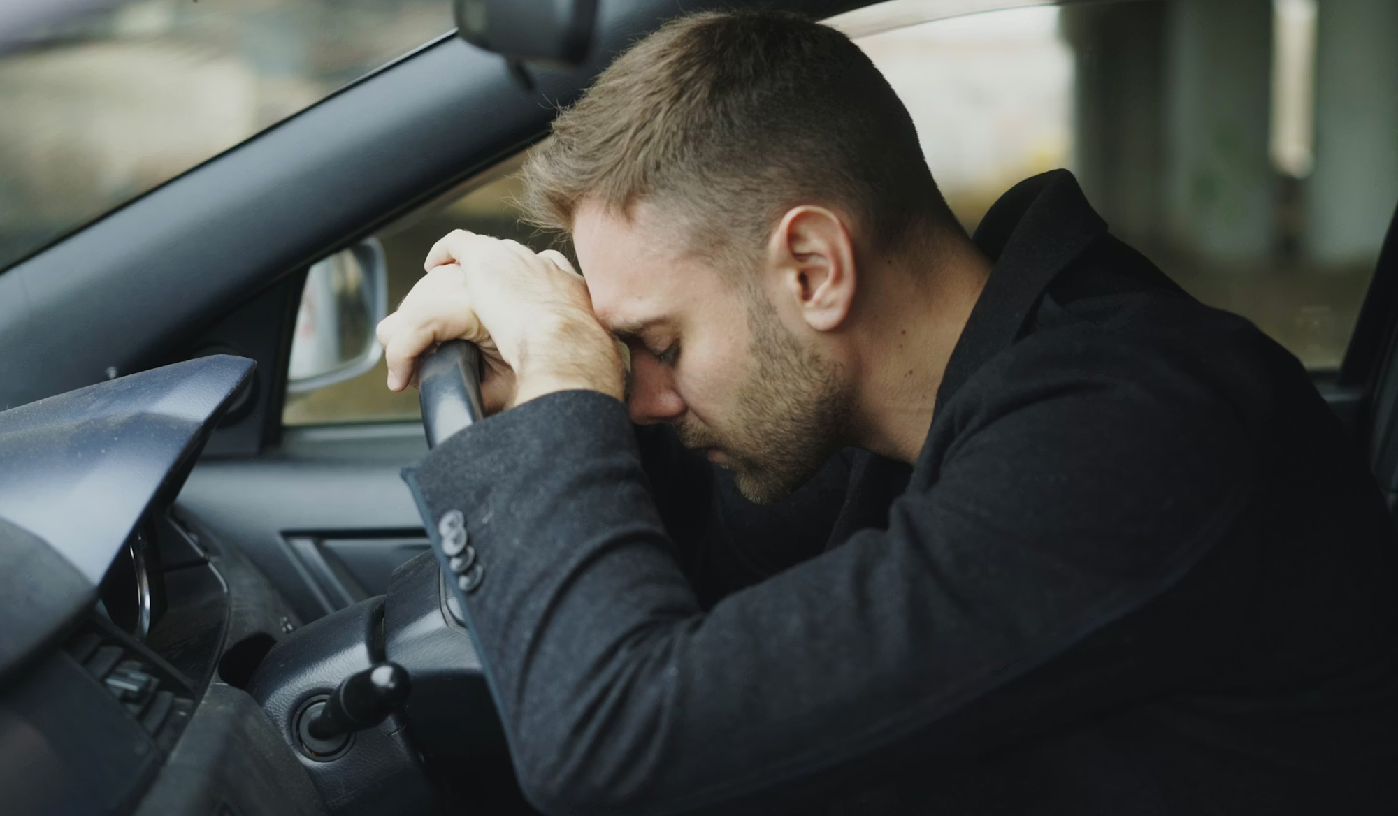 車の中で項垂れてる男性